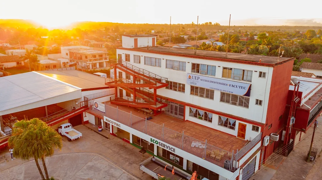 Vista aérea del edificio del Campus OPED al atardecer, con el cartel de la Facultad de Ciencias Tecnológicas